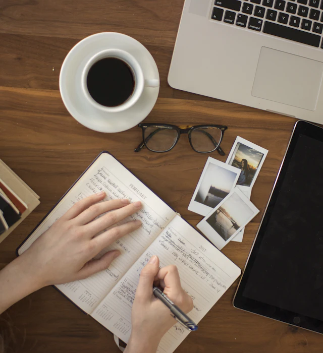 Hands writing an application in a notebook