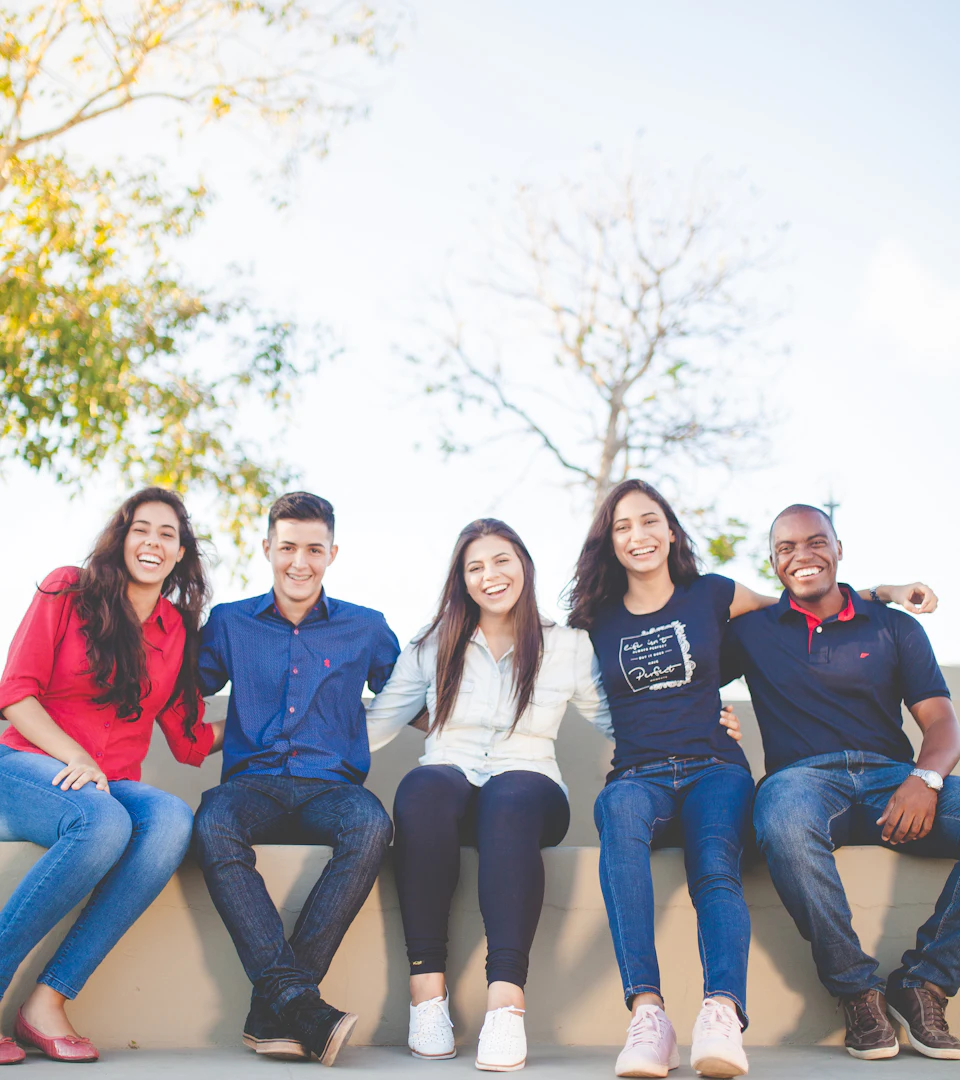 A group of young scholars smiling together outdoors